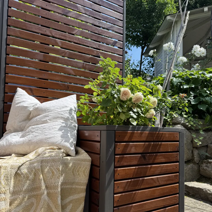 Detailansicht von Pflanzkübel, Sitzbank und Sichtschutz einer Gartenlounge