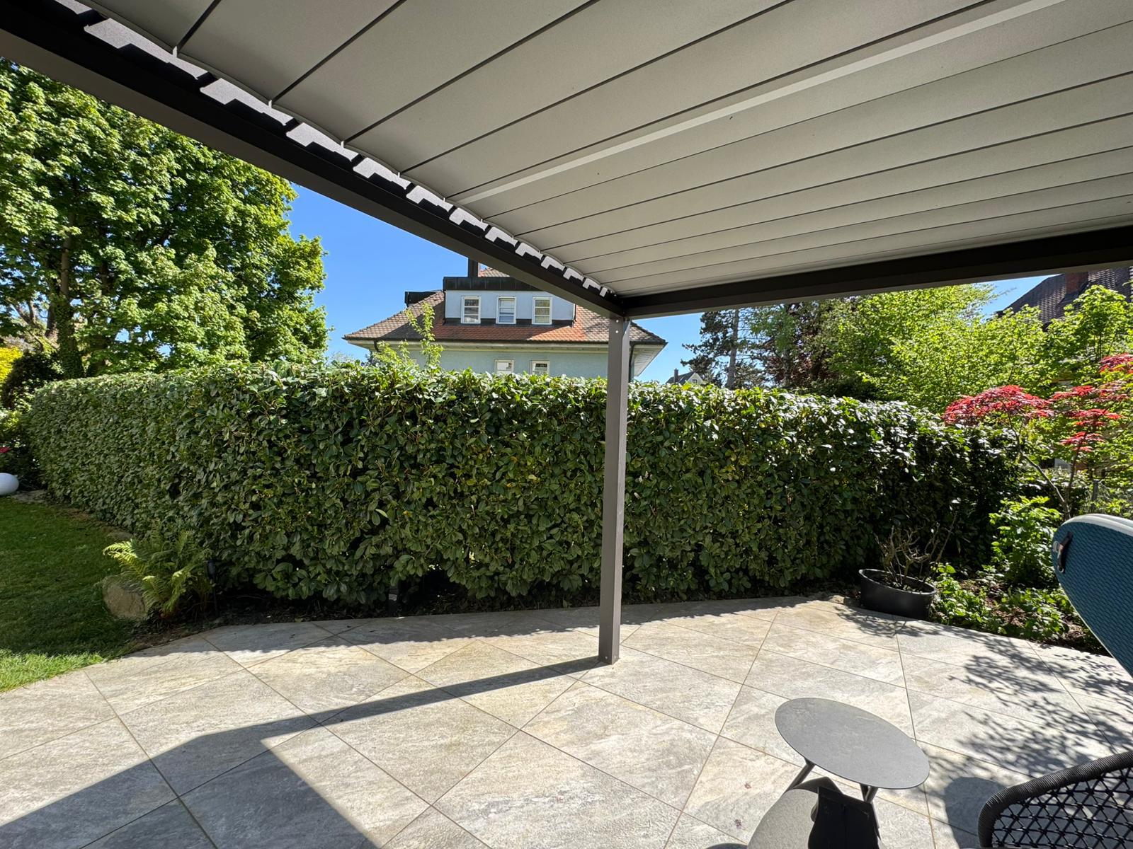 Geschnittene Hecke an einer Terrasse mit Überdachung