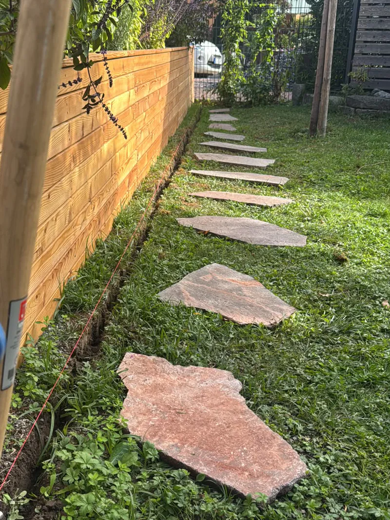 Porphyr-Trittplatten vor einem maßgefertigten Lärchenhochbeet im Garten